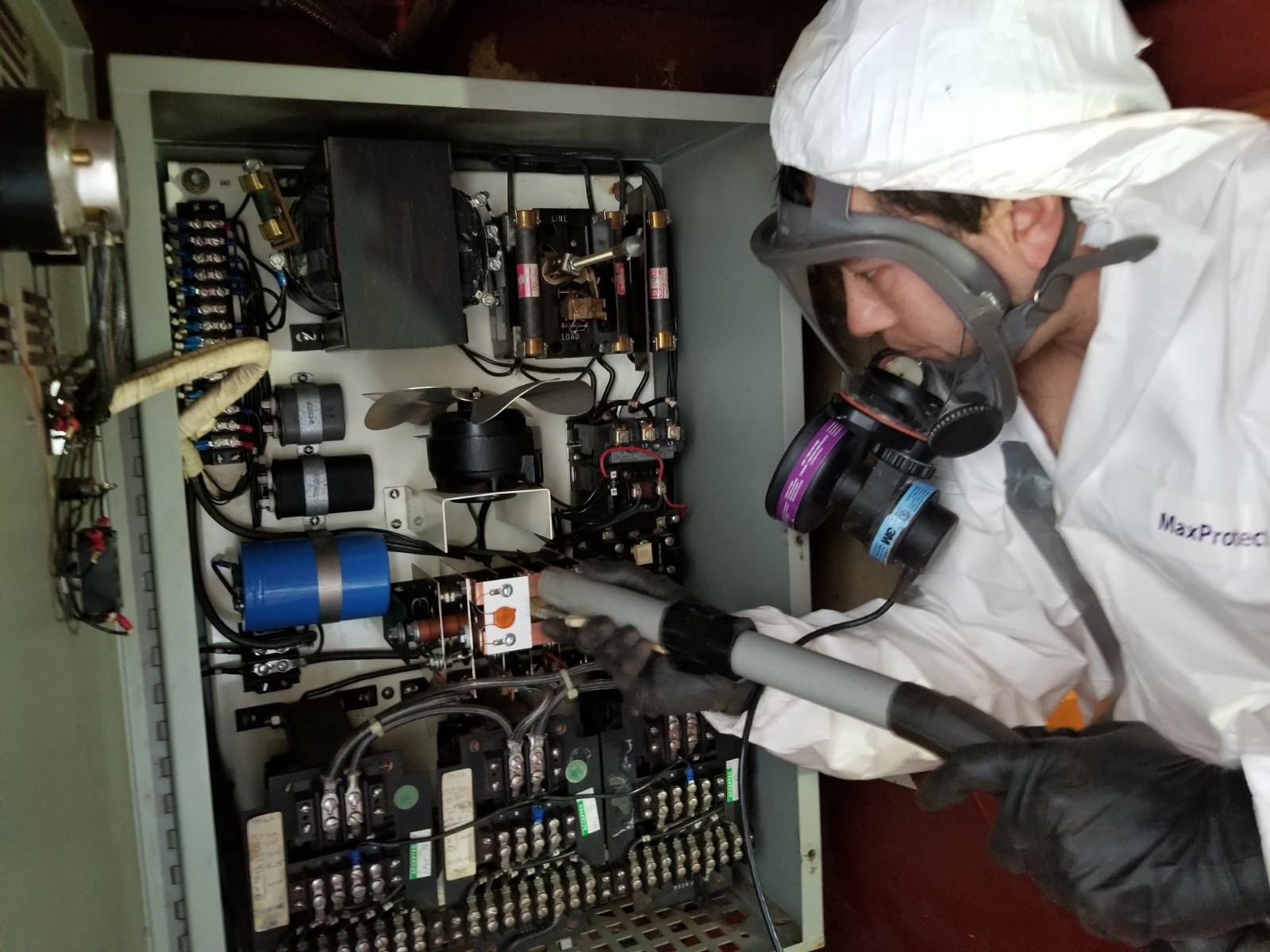 technician cleaning electronics panel